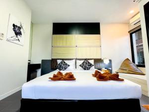 a bedroom with a large white bed with brown pillows at Leamsai Beach Resort in Suratthani