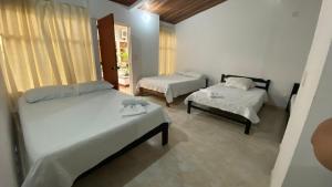 a room with two beds and a table and a bed at Hotel Tame Real in Tame