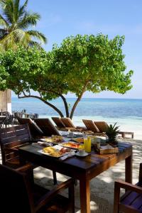 a table with food on a beach with the ocean at Blue Island Punta Rucia in Punta Rucia