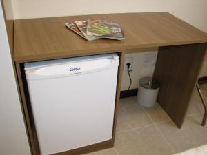 a small refrigerator under a table with a counter top at Hotel Recanto do Imperador in Rio Pardo