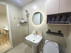 a bathroom with a sink and a toilet and a mirror at Gwanganli Breeze Bay in Kwangan-dong +25 photos