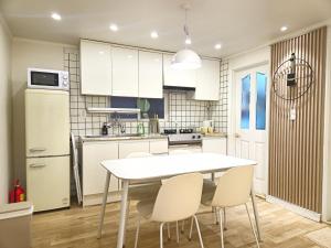 a kitchen with a white table and white chairs at Gwanganli Breeze Bay in Kwangan-dong