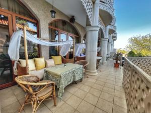 a patio with a table and chairs on a balcony at Familly Art Hotel Nirvana in Shumen