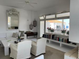 a living room with a couch and a table and chairs at The White House 1 in Andros