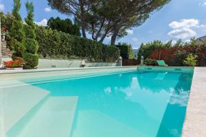 a swimming pool with blue water in a yard at Il Nido 2&2 in Staggiano