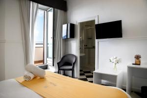 a hotel room with a bed and a chair at Hotel Stabia in Castellammare di Stabia