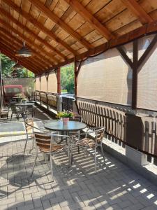 a patio with tables and chairs under a wooden roof at UbytkoMácháč in Staré Splavy