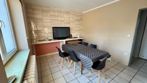 a room with a table and chairs and a television at Noclegi Witoszyn - Akacjowa 2 in Witoszyn Dolny