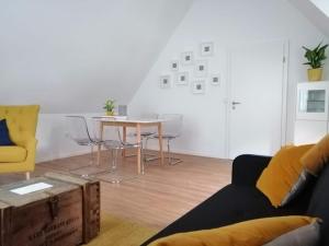 a living room with a table and a yellow couch at Weingut Stefan Meyer in Rhodt unter Rietburg