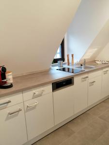 a kitchen with white cabinets and a sink at Weingut Stefan Meyer in Rhodt unter Rietburg
