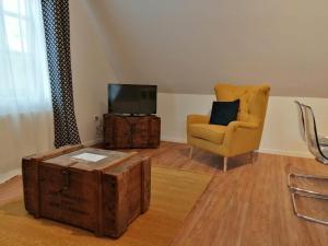 a living room with a chair and a television at Weingut Stefan Meyer in Rhodt unter Rietburg
