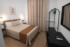 a hotel room with a bed and a table at Hostal Prada in Madrid +35 photos