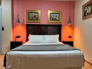 ein Schlafzimmer mit einem großen Bett und orangefarbenen Wänden in der Unterkunft Hotel Pinomar in El Puerto de Santa María