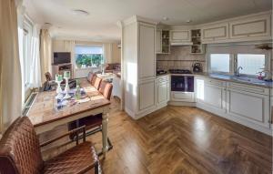 a kitchen with white cabinets and a wooden table at Nice Chalet In Putten in Putten