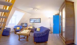 a living room with blue chairs and a table at Meeresbrise in Loperhet