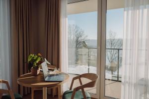 a room with a table with a laptop on it at Jezioranka Apartamenty in Ostrzyce