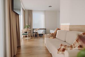 a living room with a white couch and a table at Jezioranka Apartamenty in Ostrzyce
