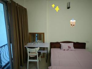 a bedroom with a bed and a table with a chair at J&J guest house in Hanoi