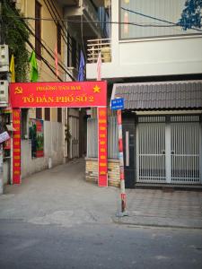 a red sign in front of a building with a gate at J&J guest house in Hanoi