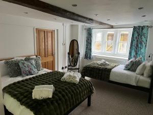 a bedroom with two beds and a window at The Cotswold Wellhouse in Tetbury +67 photos