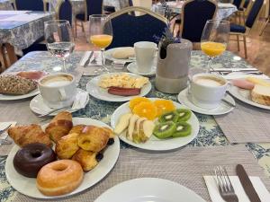 ein Tisch mit Tellern mit Frühstücksspeisen und Getränken in der Unterkunft Hotel Pinomar in El Puerto de Santa María