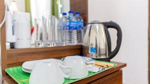 a counter with two cups and a tea kettle at Paddy Breeze Homestay in Sigiriya