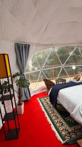 a bedroom with a bed and a red rug at Laalsa Retreat in Darjeeling