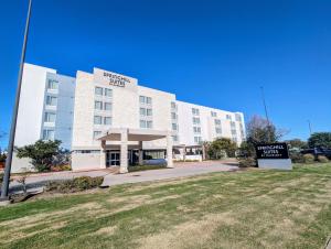 a large white building with a sign in front of it at SpringHill Suites by Marriott Houston Rosenberg in Rosenberg