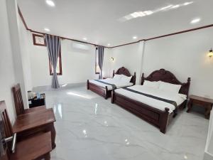 a bedroom with two beds and a television in it at Villa ThreeD Xaydara in Luang Prabang