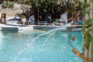 a water fountain in a swimming pool at La Madone in Apt