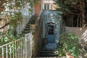 a stairway leading up to a blue door at La Madone in Apt