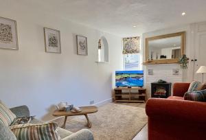 a living room with a couch and a fire place at Meads Cottage in Charmouth