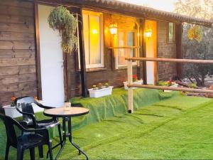 a patio with a table and chairs on the grass at חמדת השקד in Mishmār Hāyardin