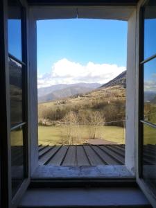 a window with a view of a field and mountains at Casa vacanze Feltre in Feltre +5 photos