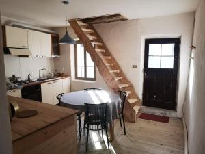 a kitchen with a table and a staircase in a room at Casa vacanze Feltre in Feltre