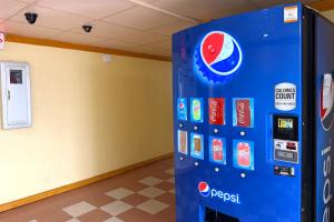 a vending machine with stickers on it in a room at Red Carpet Inn & Suites Lima -Listing Partner in Lima