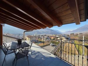 a balcony with a table and chairs and mountains at Terrazza Retica in Piateda