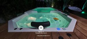 a jacuzzi tub sitting on top of a deck at Rosa Internacional - Surfland in Praia do Rosa
