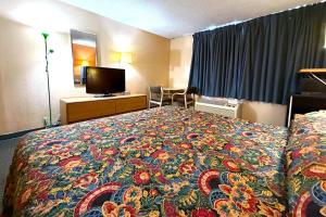 a hotel room with a bed with a colorful blanket at Red Carpet Inn & Suites Lima -Listing Partner in Lima +6 photos