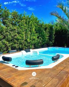 a swimming pool with chairs and a wooden deck at Rosa Internacional - Surfland in Praia do Rosa