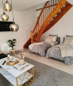 a bedroom with two beds and a staircase at Ferienwohnungen Auetal in Kucksdorf