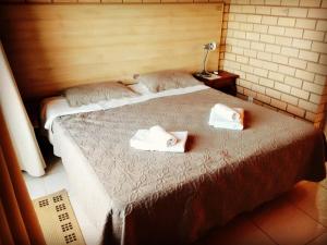 a bedroom with a bed with two towels on it at HervaDoce in Rio das Ostras +23 photos