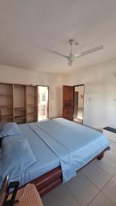 a large bed in a bedroom with a ceiling at Malindi Sunset Apartments in Malindi