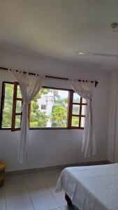 a bedroom with a bed and two windows at Malindi Sunset Apartments in Malindi