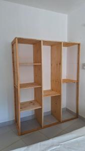 a wooden book shelf against a wall at Malindi Sunset Apartments in Malindi