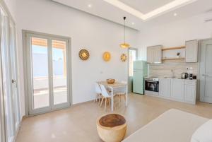 a living room with a table and a kitchen at Lipsi Grand Villas in Leipsoi +26 photos