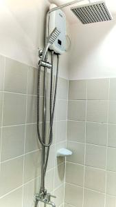 a shower with a shower head in a bathroom at Beloved's Homestay in Iruhin +10 photos