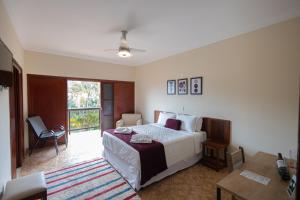 a bedroom with a bed and a table and a window at Pousada Costa Rielli in Águas de Lindoia +32 photos