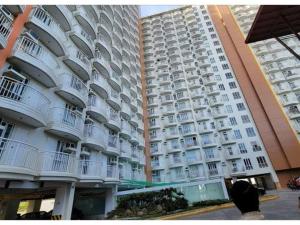 a large white apartment building with balconies at Beloved's Homestay in Iruhin
