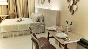 a small room with a bed and a table and chairs at Beloved's Homestay in Iruhin